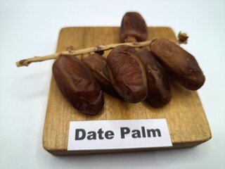 Date palm fruit on serving board. This is the edible, sweet fruit produced by the date palm tree
