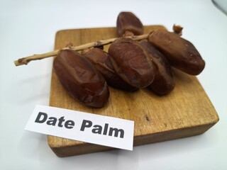 Date palm fruit on serving board. This is the edible, sweet fruit produced by the date palm tree