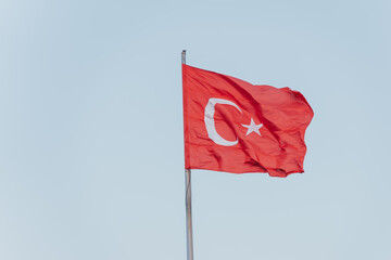 Turkish flag waving in the wind against blue sky