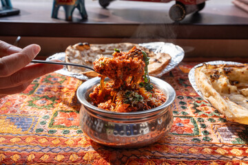 Lamb curry with tomatoes and fiery chili, traditional Indian Laal Maas served in a metal dish
