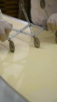 The pastry chef cuts the pastry sheet with a round knife