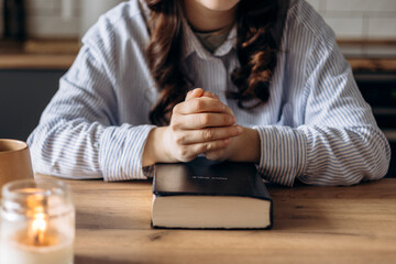Obraz premium Close-up of a woman praying in her kitchen at home in the soft morning light.