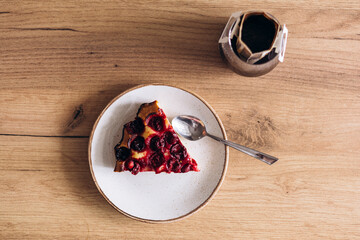 Slice of a homemade cherry pie and drip coffee on wooden table, top view.