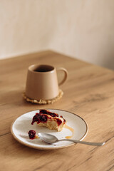 Cup of coffee and leftover cherry pie on kitchen table in the morning.
