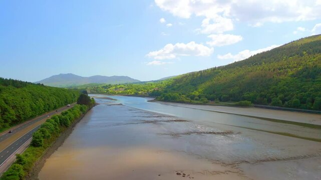 Ultra-wide aerial video of the Newry River and Mourne Mountains in Warrenpoint, County Down, Northern Ireland, UK on a bright and sunny day. Filmed in 4K, 60FPS and with Rec709 color.
