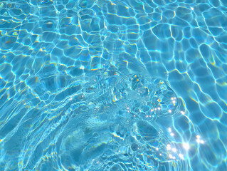 Obraz premium Sunlit Blue Pool Water Surface with Ripples and Reflections