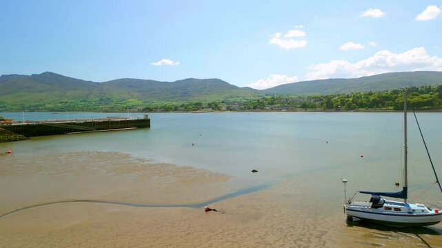 Forward travelling aerial video of the bay at Warrenpoint, County Down, Northern Ireland, UK on a bright and sunny day. Filmed in 4K, 60FPS and with Rec709 color.