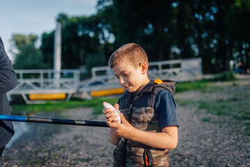 Young fisherman holding freshly caught fish by the river
