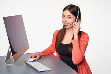 Young White woman in headset working at computer as customer support representative in bright office. Concept of remote service, communication, and professional assistance