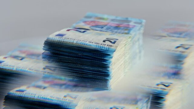 Slow motion of 20 euro bills spinning through five-sided glass prism reflection