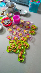 A variety of snacks and fruit salad bowls are neatly arranged on the floor, prepared for a gathering or meal event.