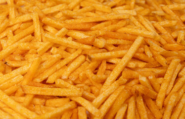 Fried chips sticks texture background, finger potato ketchup flavored chips pattern, shoestring fries