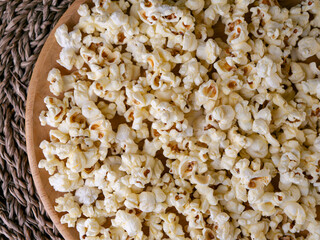 Butter salted popcorn on wooden table.