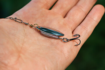 Image of a hand with a fishing lure. Spinning rod, sport fishing