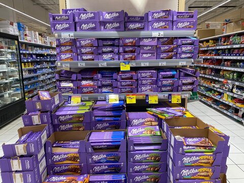Palma De Mallorca, Spain - June 07, 2025: Colorful display of Milka chocolate boxes stacked on supermarket shelves, showcasing various flavors and vibrant packaging in a retail environment