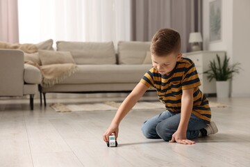 Little boy playing with toy car at home. Space for text