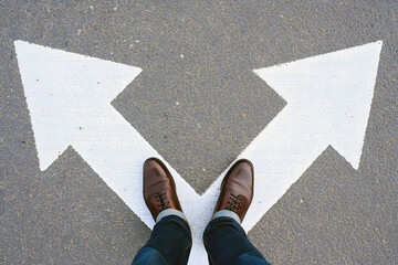Man standing between two arrows symbolizing a difficult choice, direction, or decision-making in life or business.