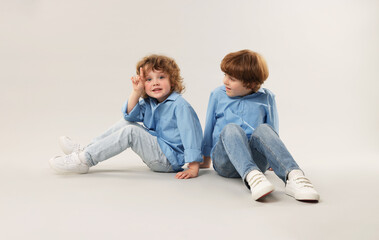 Cute little brothers together on light background