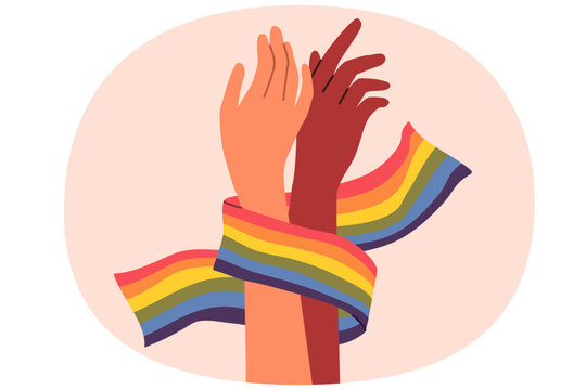 Hands of non-binary couple holding LGBT flag symbolizing love and unity between transgender and gay or lesbian. Pride month concept to promote the idea of tolerance towards LGBT people.