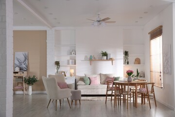Stylish dining table with chairs and comfortable sofa in room. Interior design