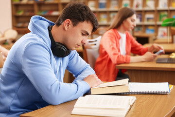 People studying at desks in public library, selective focus