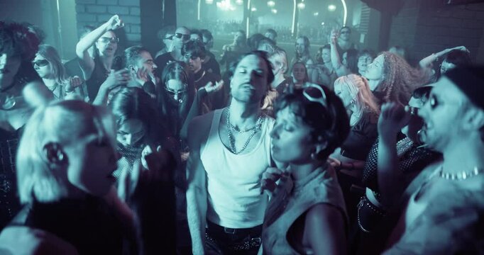Diverse Party Crowd Enjoying Time in an Underground Nightclub, Dancing Energetically Under Dynamic Lights and Pulsating Music. Young Men and Women Having an Emotional Night Out