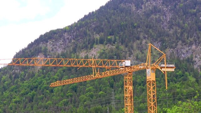 Large yellow Liebherr crane in the mountains in Tyrol Austria.