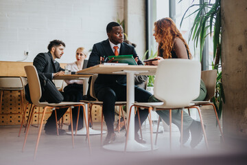 A diverse group of business people discuss ideas in a modern cafe environment, creating a vibrant...