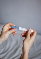 rivers of young women holding positive pregnancy test. vertical photo. pregnancy concept