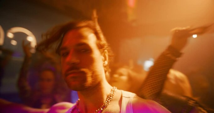 Drunk Flamboyant Man Walking on a Dancefloor, Drinking Shots, Making Out and Kissing a Hedonistic Female in the Middle of a Diverse Party Crowd. Joyful Hysterical Young Male Sitting Down to Rest