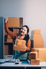 Startup SME small business entrepreneur of freelance Asian woman wearing apron using laptop and box...