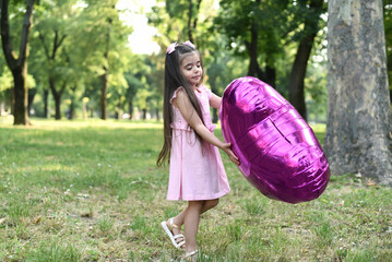 Little girl of 4 years with a big pink heart balloon