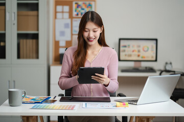 Female coder or developer working  using a Tablet and computer display in problem solving at...