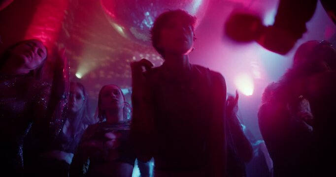Female Raver Losing Herself in the Beat at a Colorful EDM Nightclub Party. Excited Dancers Fill the Dance Floor as Electronic Music Blasts Through the Speakers. Lights Creating Surreal Party Scene
