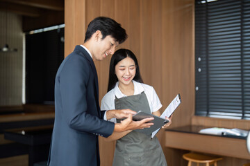 Positive Interaction. Businessman and female employee sharing a smile over a tablet.
