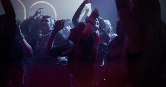 Plus-Size Female Dancer Grooves to Electronic Beats at a Colorful EDM Nightclub Party. Excited Partygoers Fill the Dance Floor as Electronic Music Blasts Through the Speakers. Slow Motion Footage