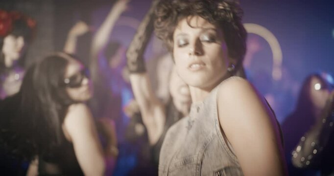 Young Caucasian Female Dancing in a Club. Stylish Clubbers Move to the Rhythm Under Bright LED Lights and Deep Electronic Dance Music. People Dancing and Enjoying Nightlife Energy