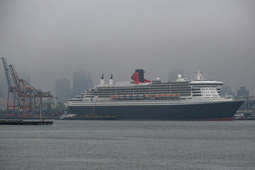 Luxury ocean liner cruiseship cruise ship Queen Mary docked at terminal in Brooklyn on grey rainy...