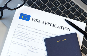 Schengen Visa application form and passport on computer. Application to register permanent...