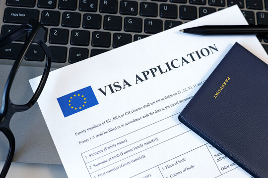 Schengen Visa application form and passport on computer. Application to register permanent residence. Immigration concept	