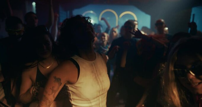 Portrait of a Female Enjoying the Party. Slow Motion Nightclub Scene with Ecstatic People Dancing Under Flashing Neon Lights. Crowd Moves to Electronic Beats in a Packed, Electric Atmosphere