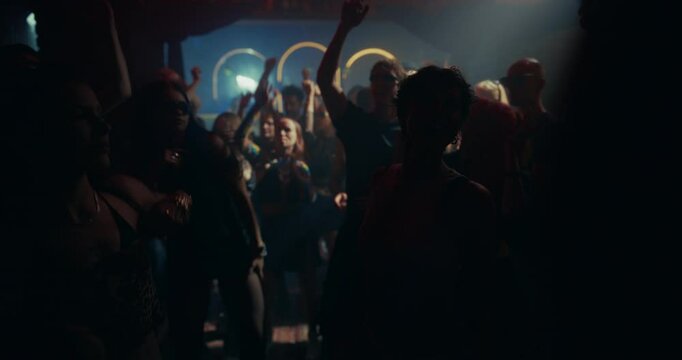 Slow Motion Footage of a Crowded Modern Nightclub with Diverse Beautiful People Dancing to Dynamic Electronic Music. Lights Pulse in Sync with the Beat. Ecstatic, Youthful and Hedonistic Mood