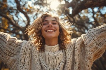 A radiant young woman joyfully stretches her arms wide under the golden sunlight, capturing the essence of happiness and freedom amidst a natural, outdoor setting with trees.