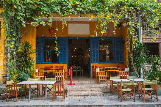Cozy and beautiful restaurant on Hoi An street with empty tables.