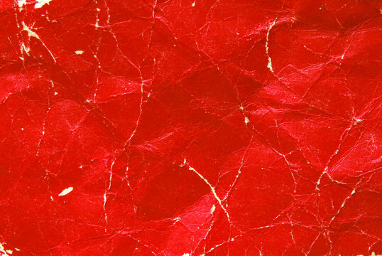 A sheet of worn red glossy paper texture as background