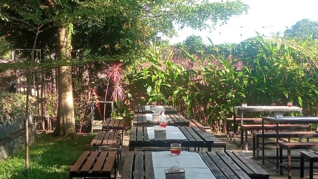 Area Tempat Duduk Outdoor di Kafe dengan Nuansa Alam Tropis