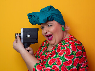 Retro plus size woman filming with vintage camera