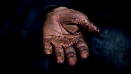 Extreme close up of a mining workers dirt stained hand shows the physical nature of underground work