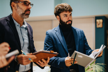 A group of business professionals engaged in a discussion during a meeting, exchanging concepts and...