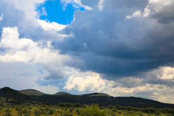 Beautiful cloud formation in the African landscape with Mountain range in the Background. Panoramic view.